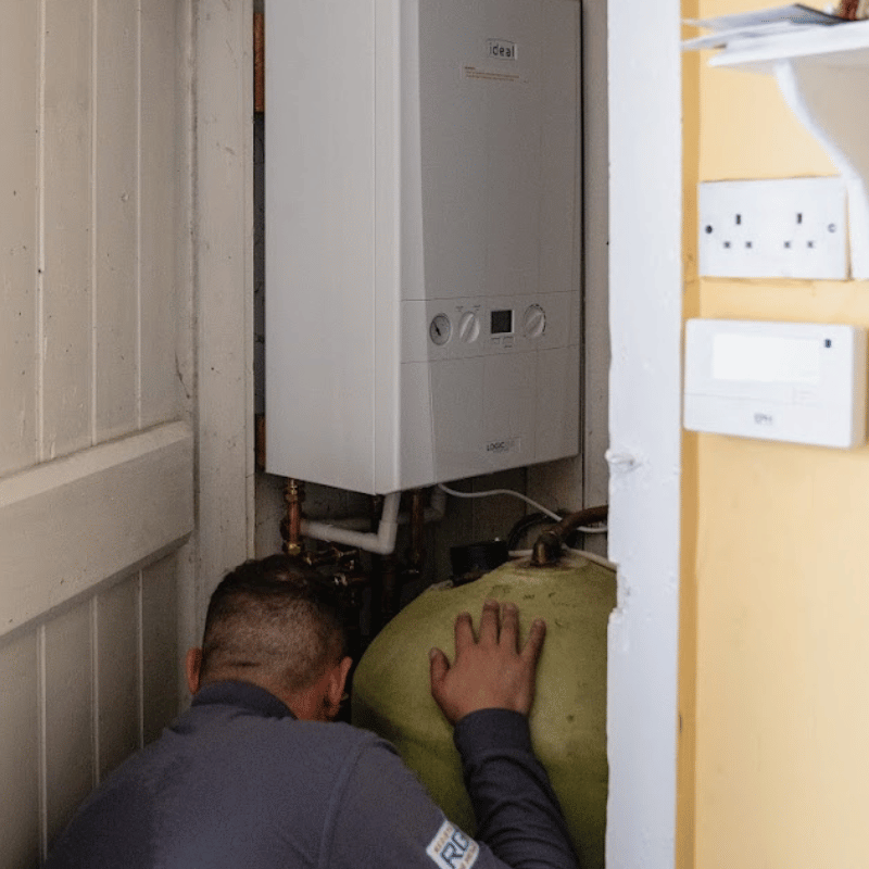 Engineer repairing boiler inside residential home