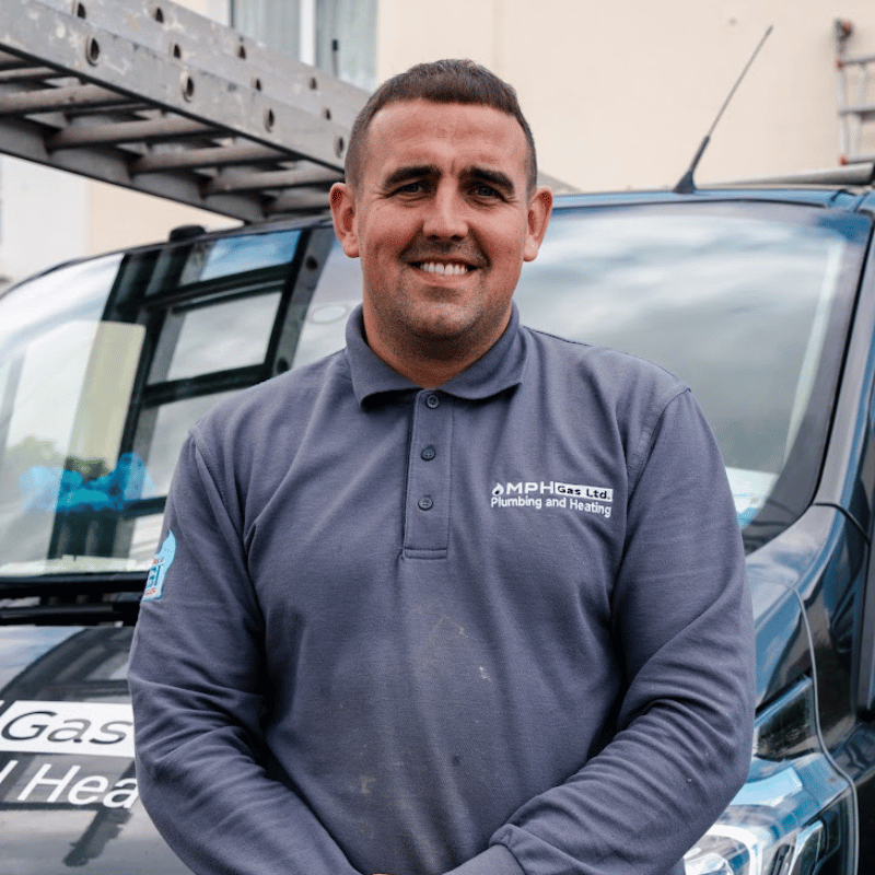 Derek Mahon, plumber, smiling outside MPH van