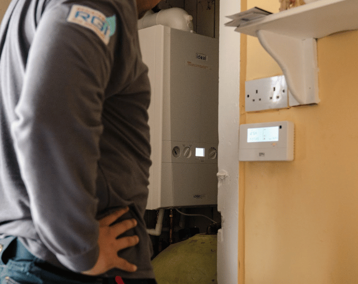 Technician in utility room installing heating system