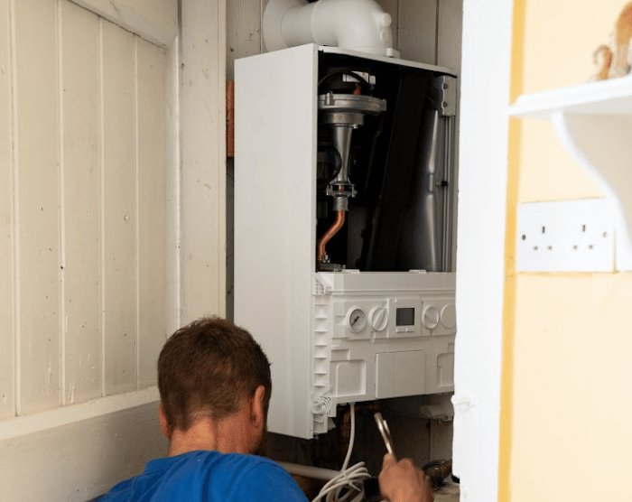 Engineer working on a wall-mounted boiler system